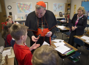 Cardinal Raymond Leo Burke, the former bishop of La Crosse who now serves as chief justice of the Vatican supreme court, visits the second grade classroom of teacher Kris Baudek (right) Thursday, December 4, 2014 at Trinity Academy in Pewaukee, Wis. The 150 student student school espouses a traditional Roman Catholic education. Thursday evening he will speak on education as a means of cultural transformation at the Country Springs Hotel in Waukesha. As part of the event, Burke will sign copies of a new book he co-authored, titled, "Remaining in the Truth of Christ." A Wisconsin native, Burke served as bishop of St. Louis before going to the Vatican in 2008. He was made a cardinal two years later. Burke confirmed in October that Pope Francis plans to remove him as prefect of the Vatican's Supreme Tribunal of the Apostolic Signatura, and install him in the largely ceremonial role as patron to the Sovereign Military Order of Malta.  MARK HOFFMAN/MHOFFFMAN@JOURNALSENTINEL.COM